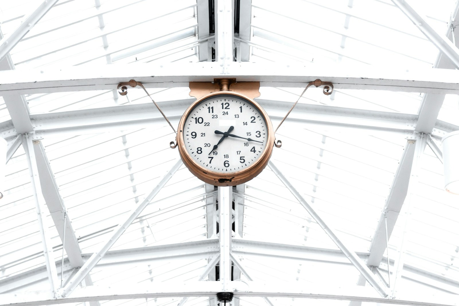 Photo by Phil Desforges round gold and white analog clock reading at 7:10